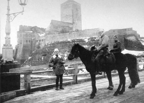 Narvan valloittaja. Luutnantti Anto Eskola ratsain takanaan Hermannin linnoituksen jykevät tornit..jpg
